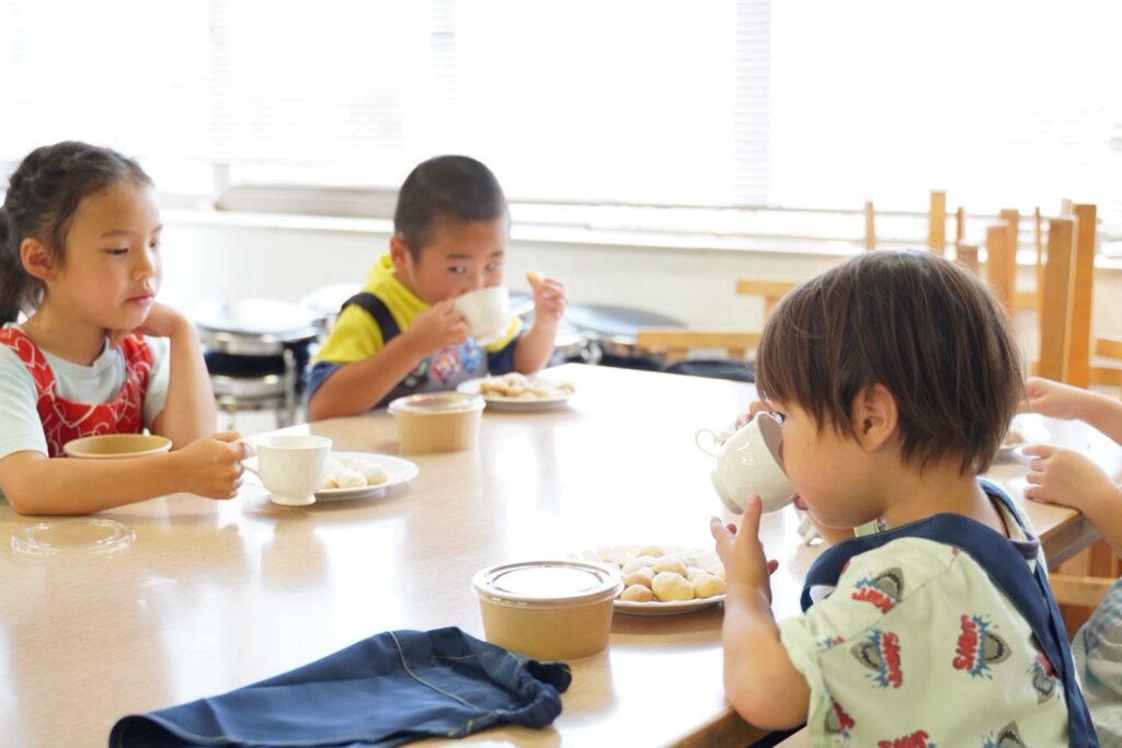 自分たちでつくったクッキーをテーブルで味わう子どもた
