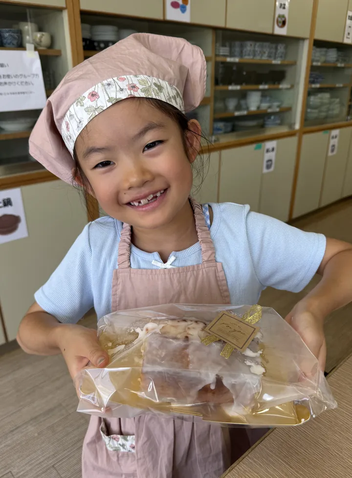 標準クラスで作ったものを両手で持って笑顔を見せる子ども