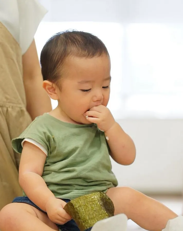 たねクラスで海苔を口に運んで味わう赤ちゃん