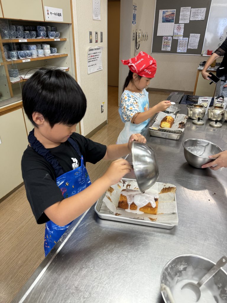 焼きたてのレモンケーキに、アイシングをかける子ども
