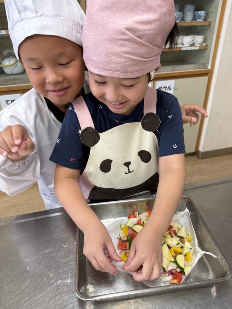 夏野菜と豚肉を楽しそうに調理する子どもたち