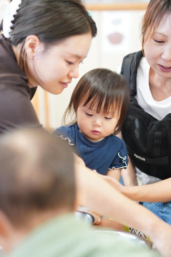 先生とお母さんに見守られながら教室に参加する女の子