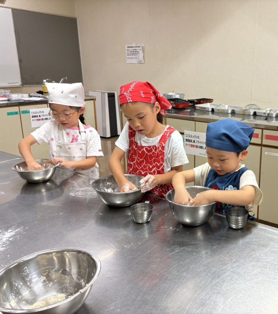 ボウルの中で白玉の生地をこねる子どもたち