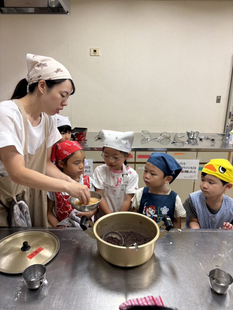 鍋のあんこをのぞき込む子どもたちと先生
